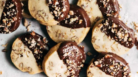 Toffee pecan shortbread cookies stacked on a neutral background