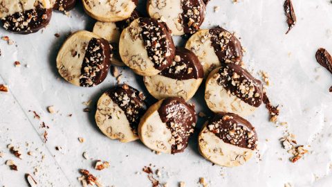 Toffee pecan shortbread cookies stacked on a neutral background