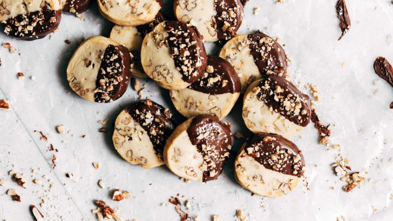 Toffee pecan shortbread cookies stacked on a neutral background