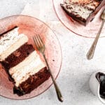 Slice of angel food and chocolate cake with peanut butter mousse on pink plate and grey background