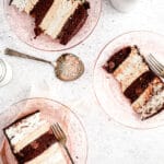 Slice of angel food and chocolate cake with peanut butter mousse on pink plate and grey background