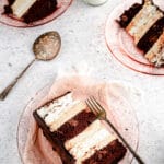 Slice of angel food and chocolate cake with peanut butter mousse on pink plate and grey background