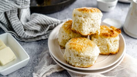 Four Vanilla Flecked Flaky Biscuits stacked on a plate