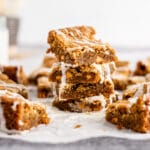 Chewy Vanilla Blondies stacked in pile on neutral background