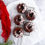 Chocolate donuts with chocolate glaze and crushed peppermint candies on cooling rack
