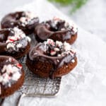 Chocolate donuts with chocolate glaze and crushed peppermint candies on cooling rack