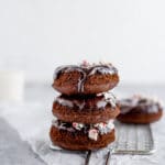 Chocolate donuts with chocolate glaze and crushed peppermint candies on cooling rack