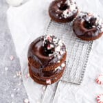 Chocolate donuts with chocolate glaze and crushed peppermint candies on cooling rack
