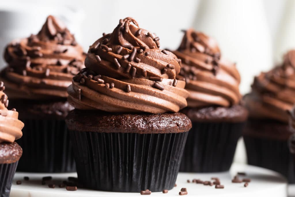chocolate cupcakes with chocolate frosting on neutral background