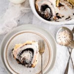 chocolate cinnamon rolls with white frosting in baking dish