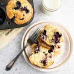 Golden blueberry muffins in muffin tin on neutral background