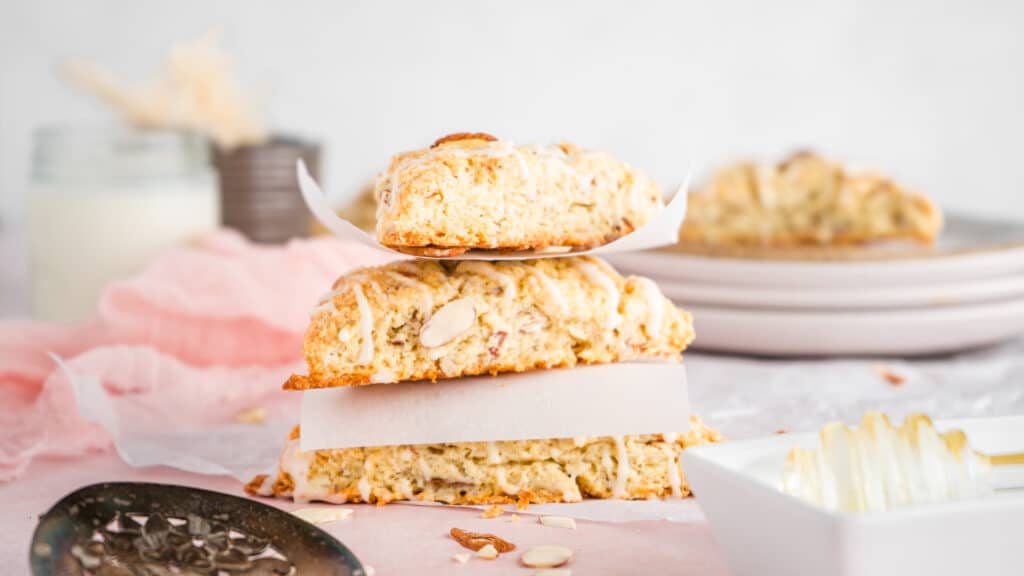 Honey Nut Almond Scones stacked on neutral background with almond slivers