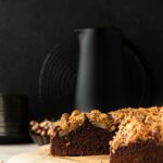 Side view of spiced chocolate pear cake against dark background