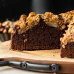Side view of spiced chocolate pear cake against dark background