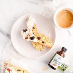 Almond Cherry Biscotti dipped in white chocolate on white plate on top of marble background
