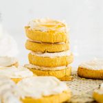 Cornbread cookies with honey frosting stacked on a neutral background