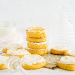 Cornbread cookies with honey frosting stacked on a neutral background
