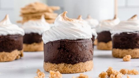 Multiple chocolate cheesecakes on graham cracker crust with meringue topping on neutral background