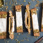 Puffy vanilla danish with vanilla glaze and pistachios on a slab of marble