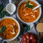 bowls of orange pumpkin soup on wooden background