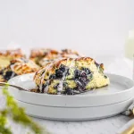Creamy Lemon Blueberry Scone laying on a white plate.