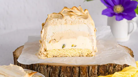 Baked Alasaka cut opened on a wooden serving board with parchment paper.