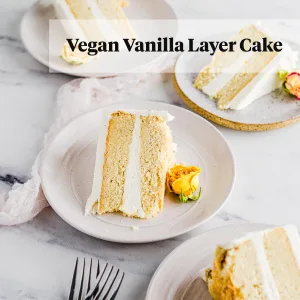 vegan vanilla layer cake on white marble with ceramic plates and forks
