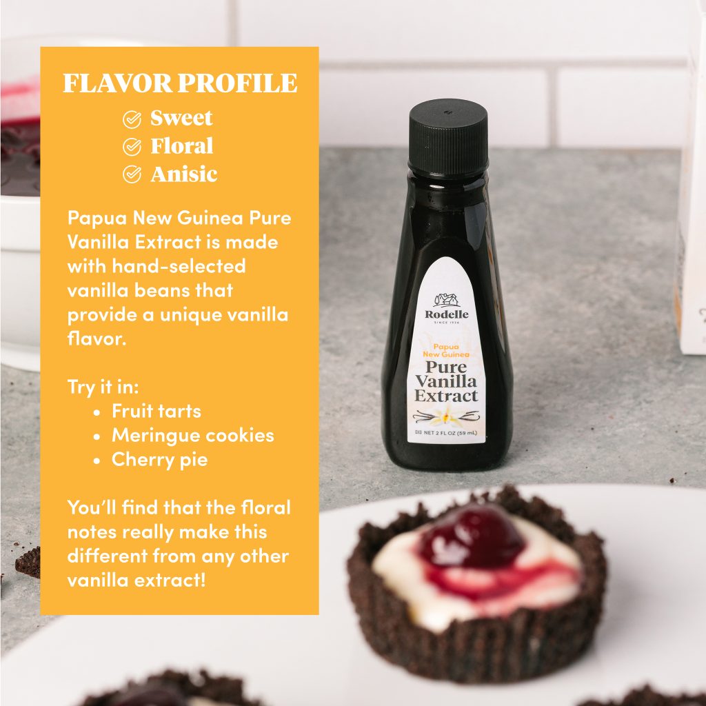 lifestyle image of a cherry cordial tartles in the forefront, blurry and focus on a 2oz Papua New Guinea Pure Vanilla Extract bottle. To the left in the yellow box is info on papua new guinea vanilla extract